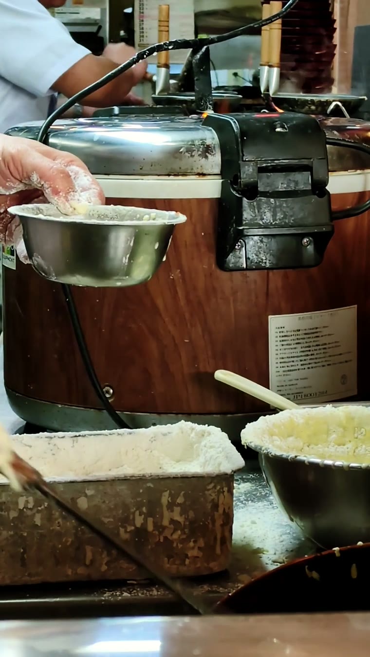 Hand mit Zange über den Töpfen